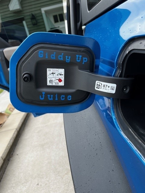 The inside of a fuel tank door says Giddy Up Juice